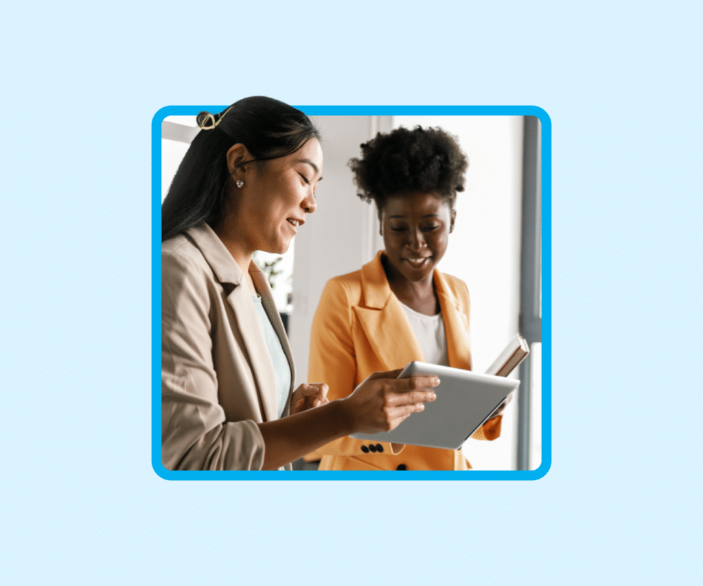 Two professional women looking at a tablet